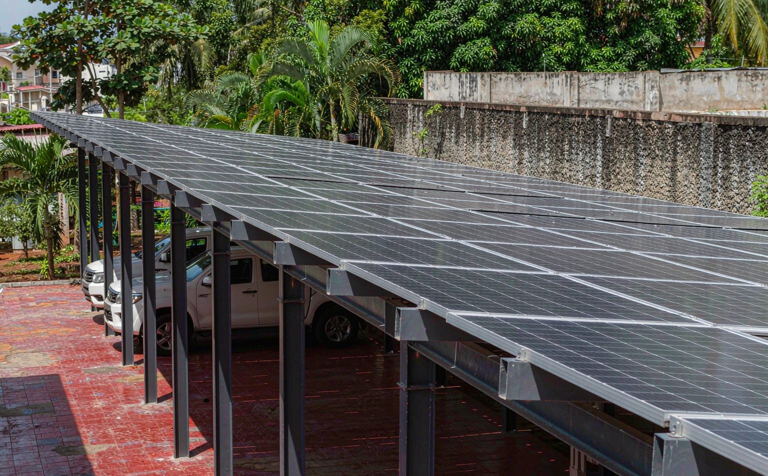 Solar carport canopy over parked vehicles in a company yard in Ghana, a mounting option that changes solar panel price in Ghana