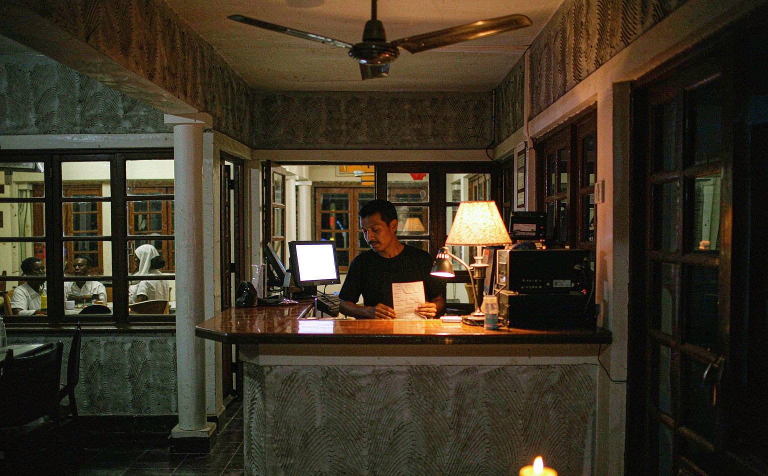 Hotel lobby lit only by emergency lamps during a grid outage, one cause of power outage cost for hotels in Nigeria