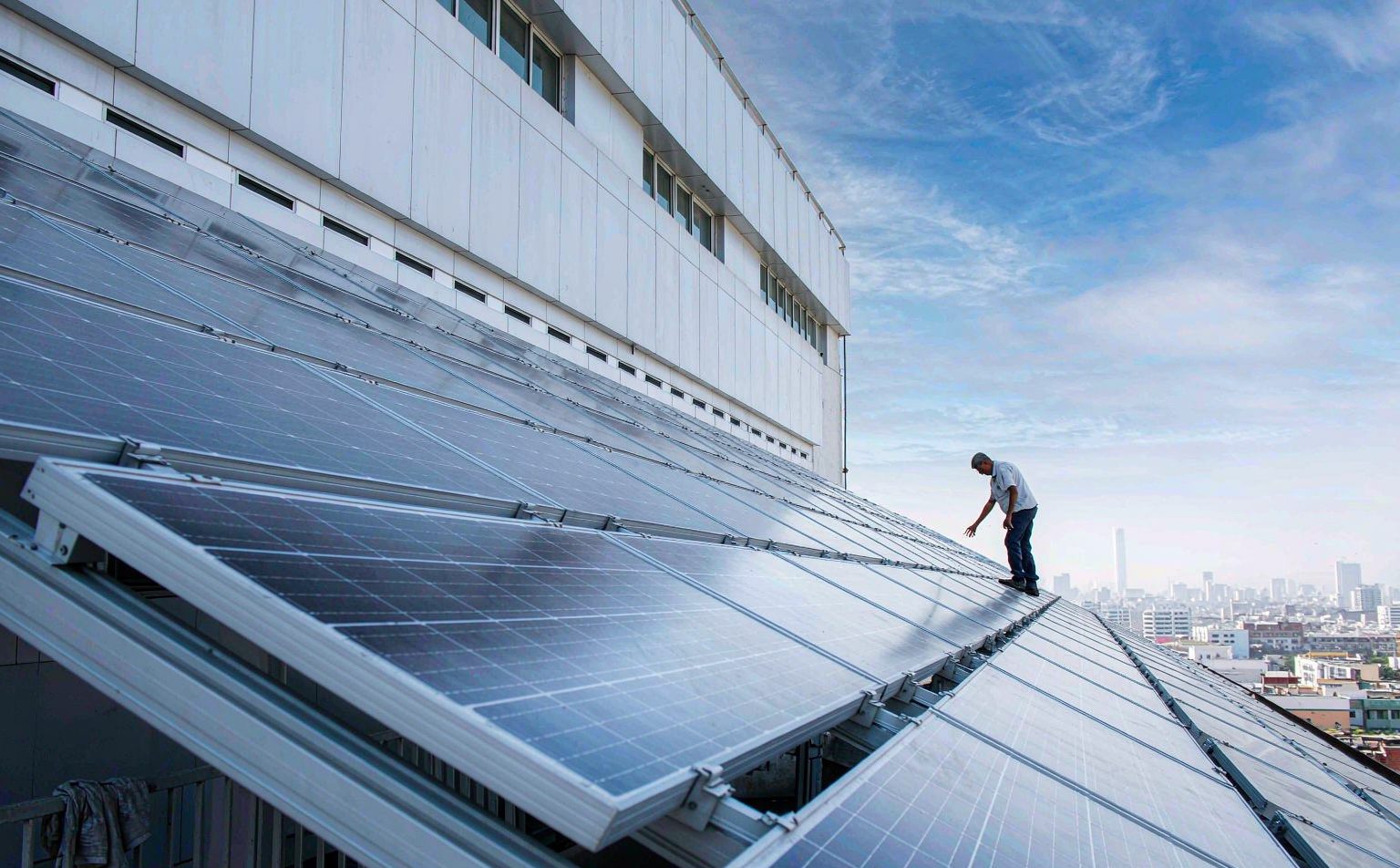 Technician inspecting a rooftop solar array in Nigeria, the practical answer to power outage cost for hotels in Nigeria